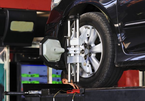 Car wheel fixed with computerized wheel alignment machine clamp.